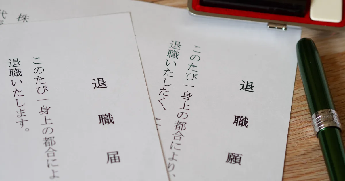 退職届と退職願の書類が並べられている。退職願には『退職いたしたく』、退職届には『退職いたします』と記載されている。