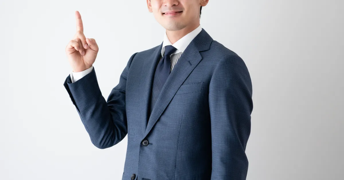 スーツを着た男性が指を指してポイントを示している様子。退職を切り出す際の重要なポイントを伝えるイメージ。