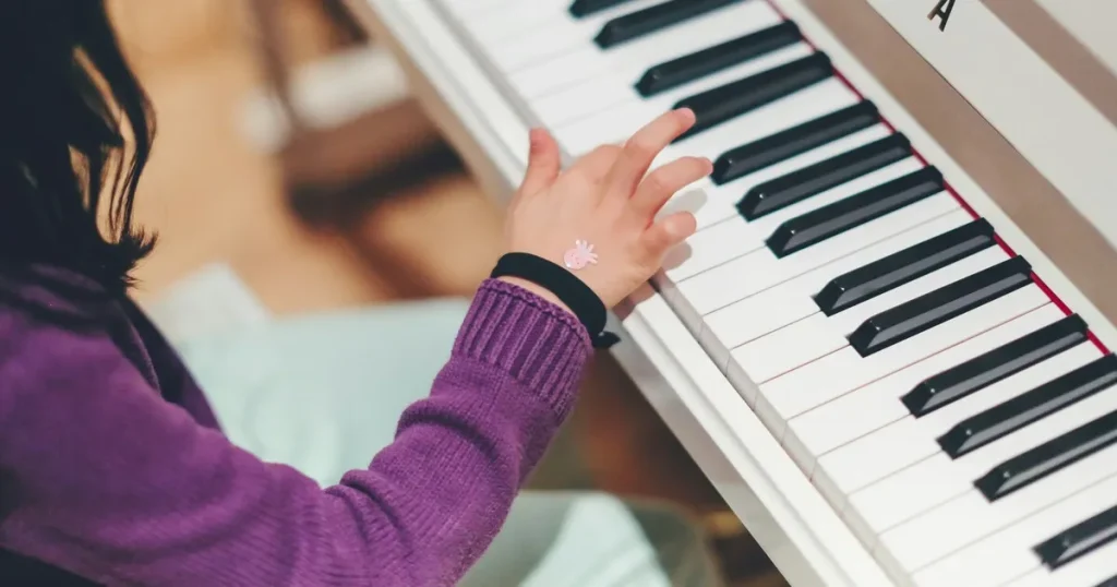 ピアノを弾く子どもの手。成功のための準備や努力を象徴するイメージ。