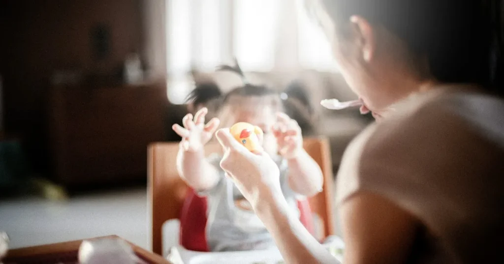 母親が赤ちゃんに食事を与えている様子。育休中の生活を象徴するイメージ。