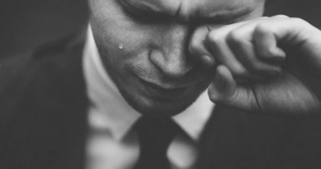 涙を流す男性の白黒写真。失敗や面接での挫折を象徴し、準備不足や対策の重要性を示すイメージ。