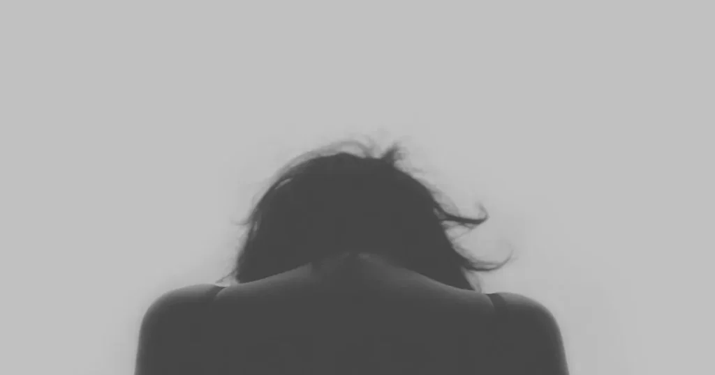 頭を抱える人の後ろ姿。面接に落ちるサインや対策を考えるシーンを象徴するイメージ。
