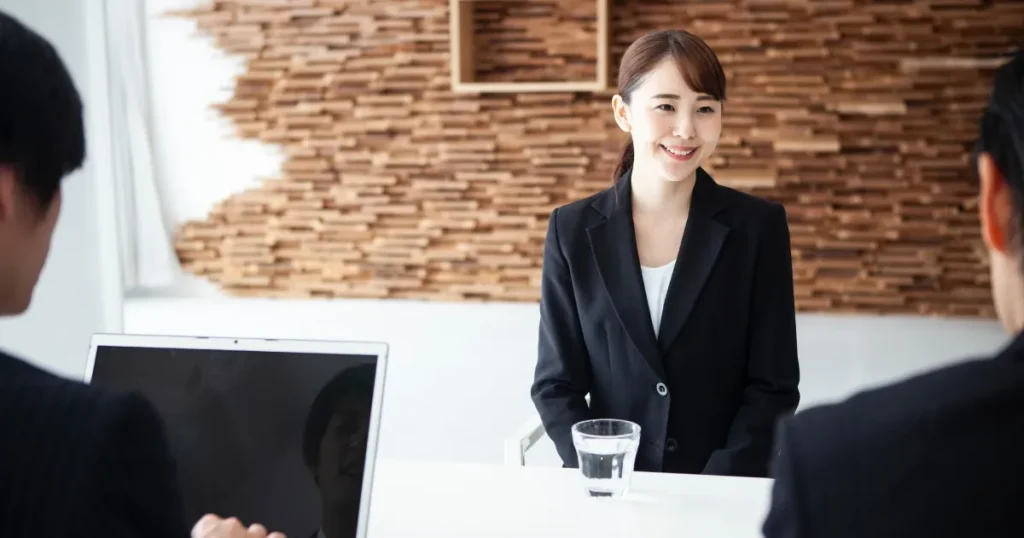 面接中の女性 - 清潔感のあるまとめ髪スタイルで笑顔を見せる就活生