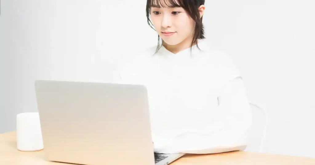 ノートパソコンに向かって作業する女性 - 就職情報サイト利用時の注意点を意識するイメージ