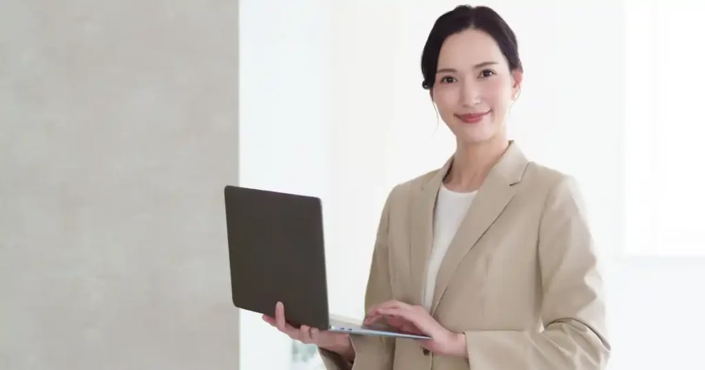 ノートパソコンを持ち微笑むスーツ姿の女性 - 非正規雇用から正社員への転職を支援する制度について説明するセクション