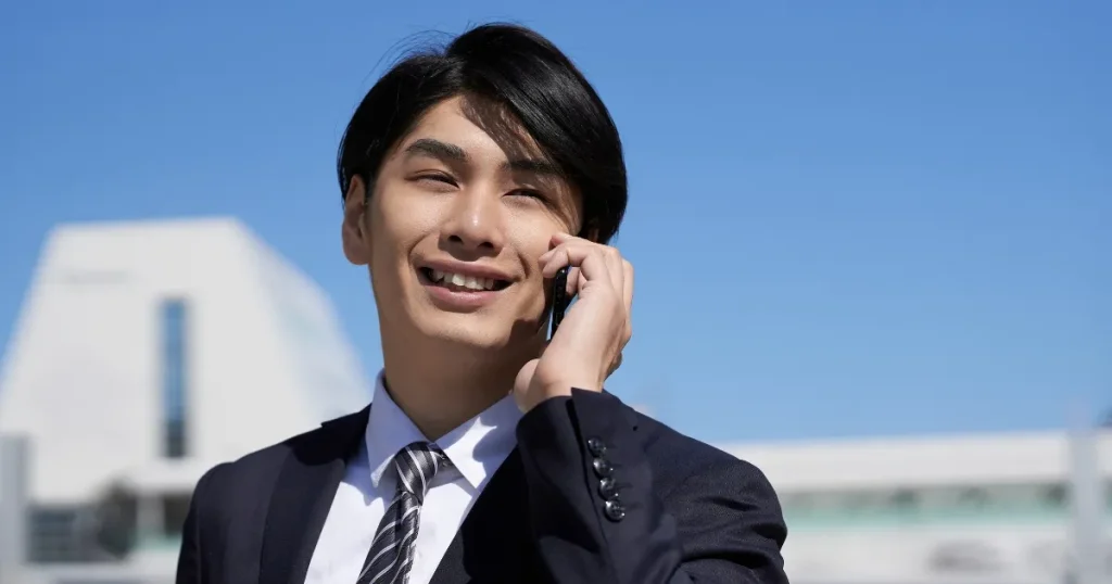電話で会話をするスーツ姿の男性 - 社会人デビュー時の注意点について説明するイメージ