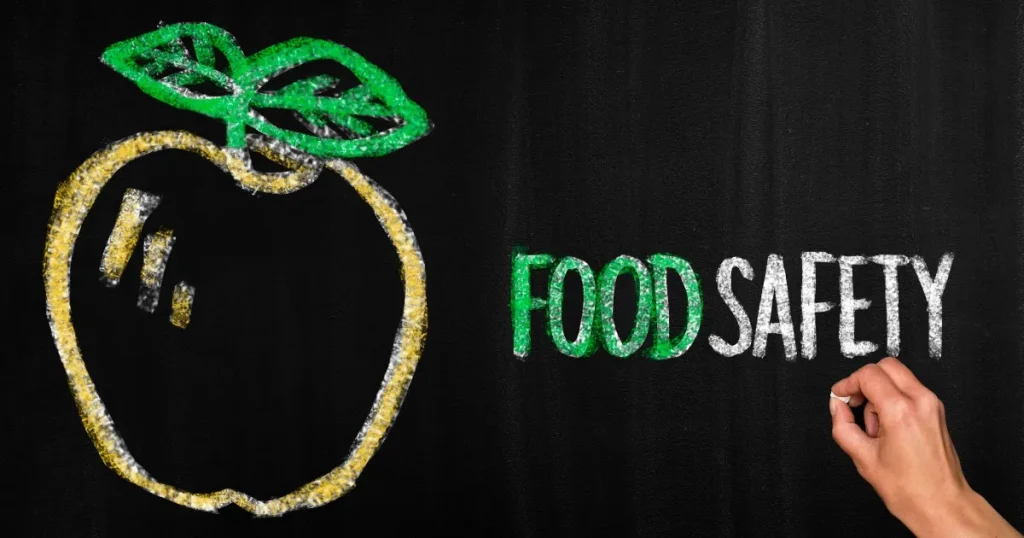 黒板に描かれたりんごと『FOOD SAFETY』の文字 - 食品衛生の重要性を示すイメージ