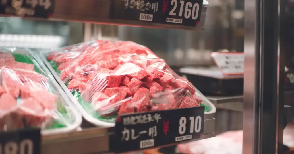 精肉店のショーケースに陳列された包装済みのカット肉。精肉店で必要な技術やスキルを象徴するイメージ。