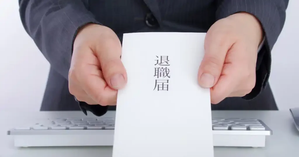 退職届を両手で差し出すスーツ姿の人物。即日退職について説明するセクションをイメージした画像。