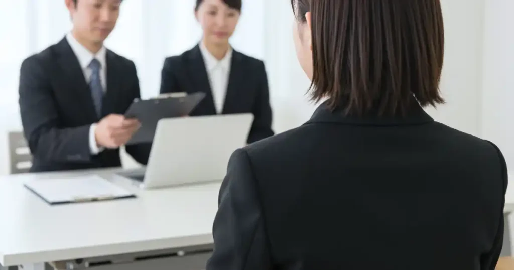 面接官が書類を持ちながら応募者に質問をしている様子。面接でよく聞かれる質問について説明するセクションに使用される画像。