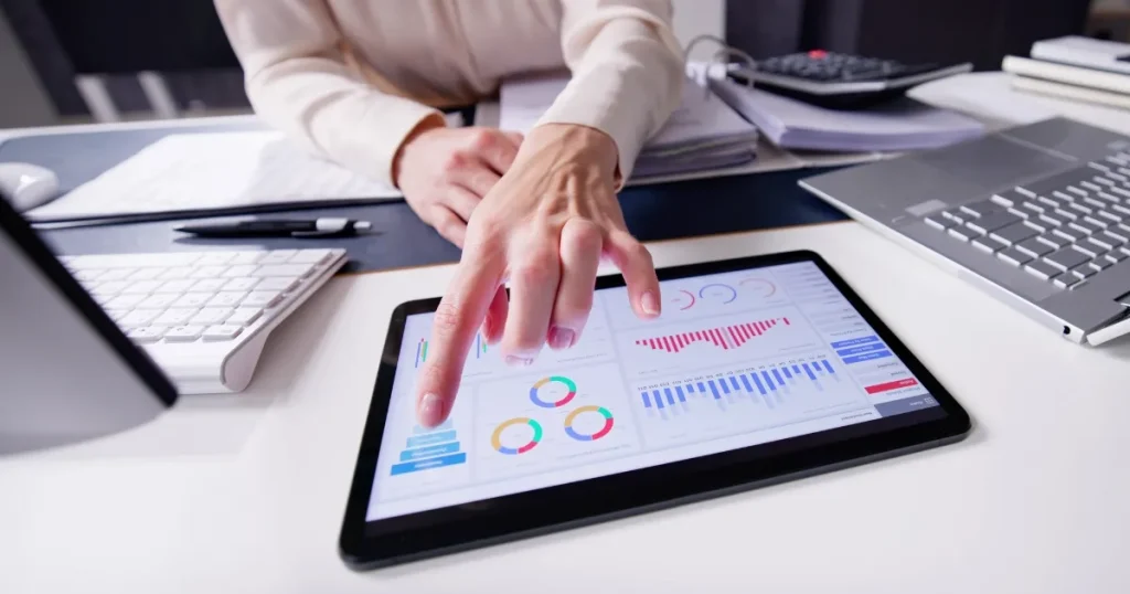 タブレット上のデータやグラフを指差す手。転職活動に役立つ求人情報や企業情報の分析を示すイメージ。