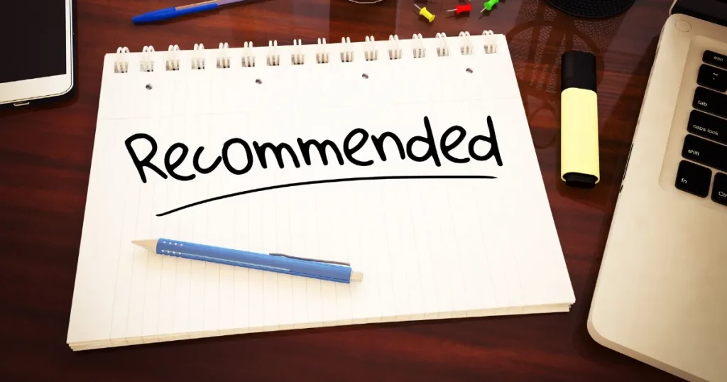 「Recommended」と書かれたノートとペン、デスク上のアイテム。学校推薦の求人票の利点を象徴的に表現。