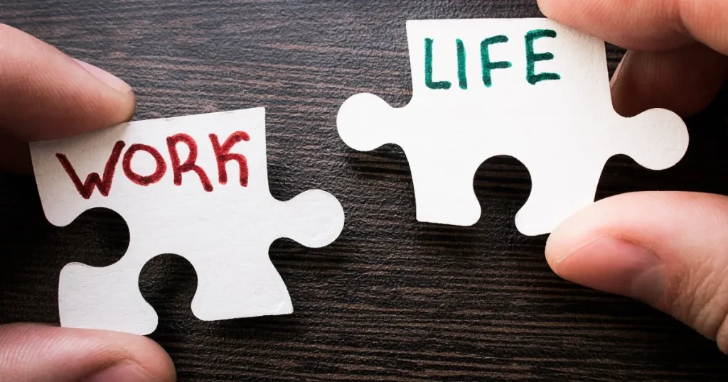 「WORK」と「LIFE」と書かれたパズルのピースを組み合わせる手元：仕事と私生活を調和させるワークライフバランスの重要性を表現。