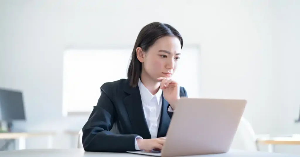 就活に出遅れる原因について考え込むスーツ姿の女性。就活の遅れを招く要因と対処法を解説するセクションに関連。