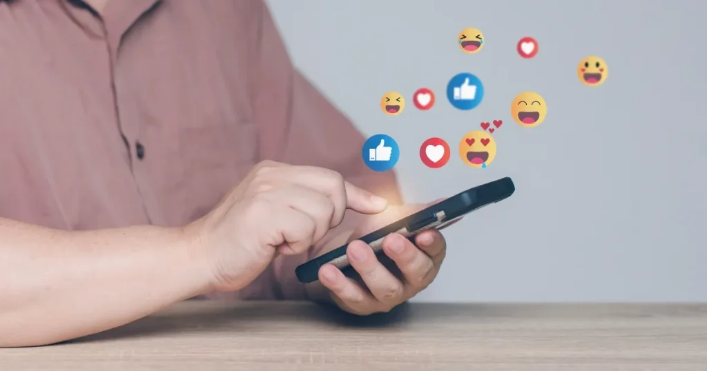 スマートフォンを操作する手と、画面から浮かび上がる「いいね」や「ハート」などのアイコン。就活でインスタの問い合わせを行う際に採用担当者に好印象を与えるポイントを解説するセクションに関連。